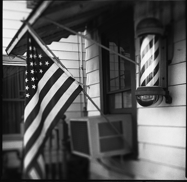 Flag and striped barber pole in union town 